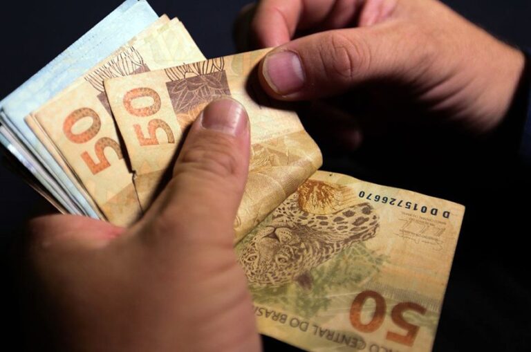 Pessoa contando dinheiro, salário mínimo 2026.